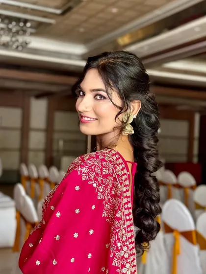 A beautiful smile to complete the look. This client is glowing in her party-ready lehenga, with makeup that enhances her features and a hairstyle that adds glamour.