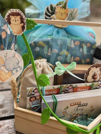 A look at the curated items inside the jungle hamper, including themed books and a personalized water bottle.