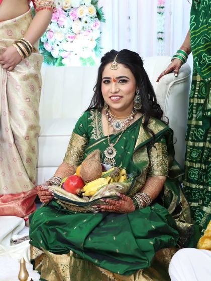 The bride participating in a traditional ritual during her engagement ceremony. Her makeup is designed to be both beautiful and long-lasting.
