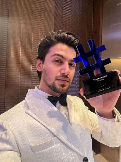 Our client celebrating his win. The bespoke fit of the white tuxedo jacket ensures he looks sharp and feels comfortable throughout the evening's festivities.