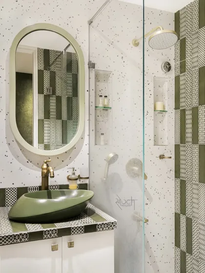 The Olive Lavatory, where olive green patterned tiles, terrazzo, and brass accents create a symphony of design.