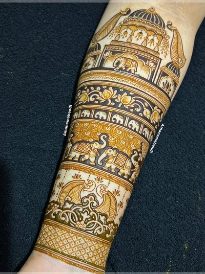A full view of an intricate bridal arm design. It features multiple bands of patterns, including palace architecture, rows of elephants, and floral motifs.