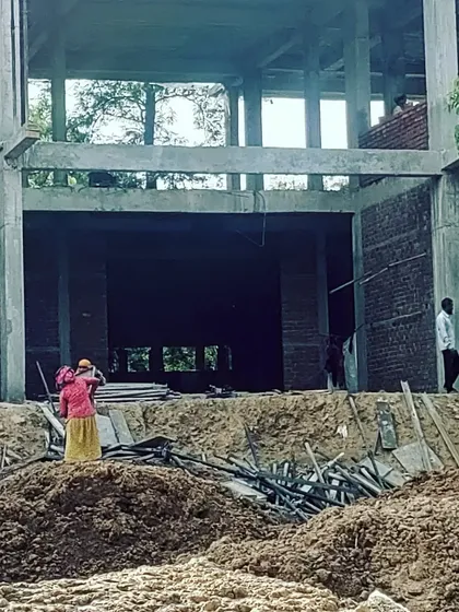 A ground-level view of the farmhouse construction site. This image highlights the foundational work and the concrete skeleton of the building, illustrating the initial phases of bringing a large-scale architectural vision to life.