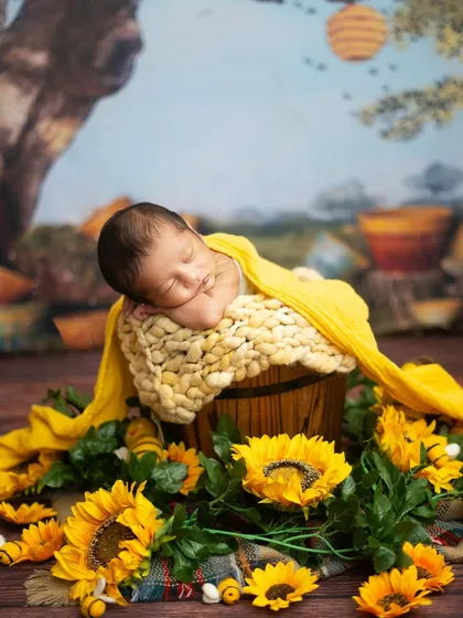 A side profile of a newborn sleeping peacefully in a sunflower-themed setup. This angle highlights the sweet curve of their cheek and their tiny button nose.