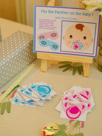 A fun and simple game for all ages: 'Pin the Pacifier on the Baby'. I set up this station with custom-printed game boards and pacifier cutouts, making it an easy and interactive part of the celebration.