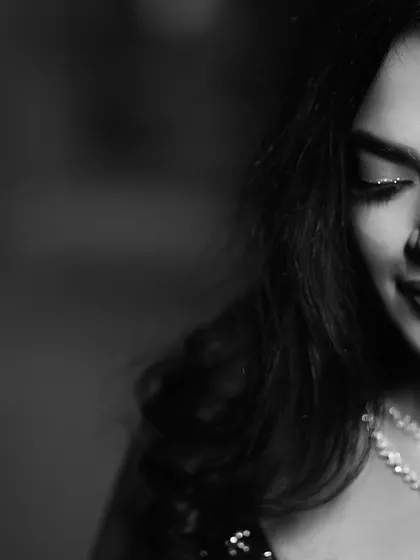A timeless black and white portrait of the bride, her eyes closed in a moment of quiet contemplation. The shot beautifully highlights her delicate diamond necklace and elegant makeup.