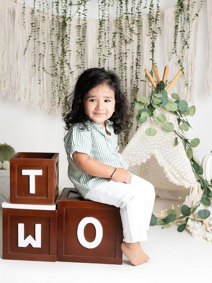 This adorable two-year-old has the most gorgeous hair! The green and white theme with a mini teepee creates a fresh and natural look for a second birthday photoshoot.