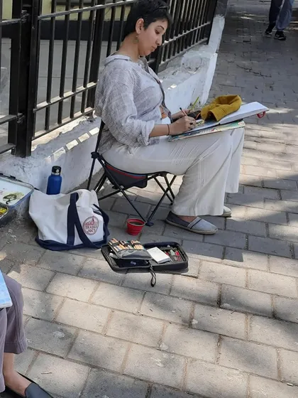 Another shot of me sketching on location. You can see my portable setup, including my sketchbook, paints, and foldable chair, which allows me to paint anywhere.