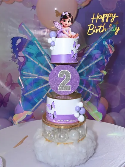 A close-up of our kinetic butterfly cake for a second birthday. The iridescent wings and purple details create a magical centerpiece for a fairy-themed party.