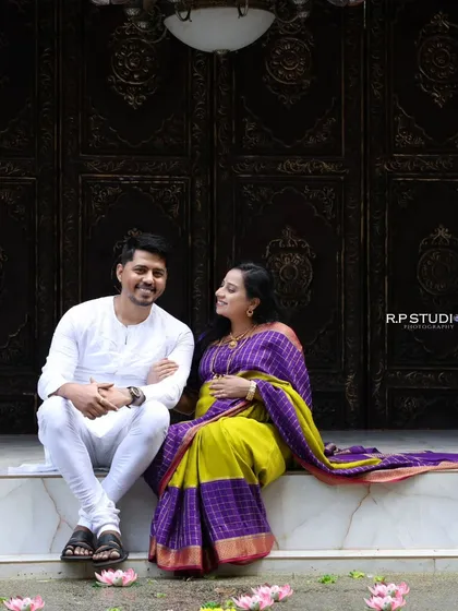 An outdoor traditional maternity shoot set against an ornate, carved wooden doorway. The setting adds a sense of history and grandeur to this beautiful couple's portrait.