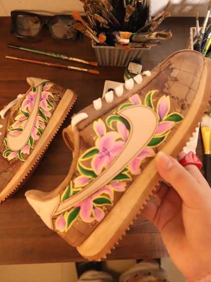 A side view of the world map and lily design on the Nike Cortez. The coffee-dye technique ensures that even the unpainted areas of the shoe have a rich, vintage character.