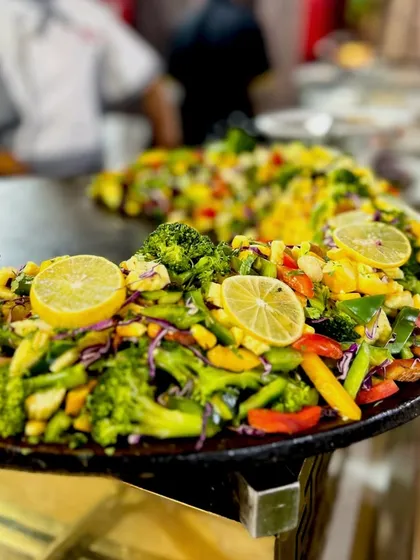 A wide view of my English Vinglish Chaat station. A large tawa is filled with a colourful assortment of stir fried vegetables like broccoli and baby corn, ready to be served as a healthy chaat.
