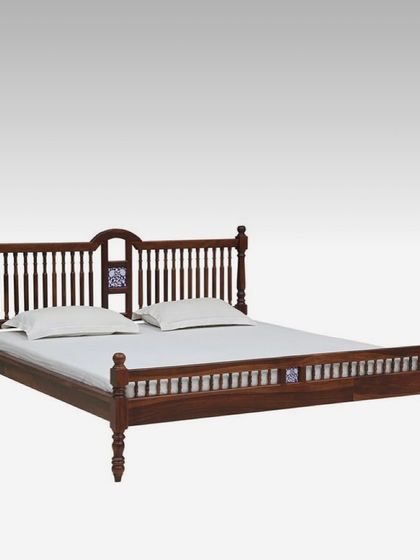 A studio shot of our traditional Sal wood bed. The dark wood polish highlights the natural grain and the detailed craftsmanship in the spindle work and decorative tile accents.