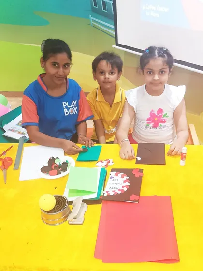 Children and an instructor pose with their completed Mother's Day crafts.