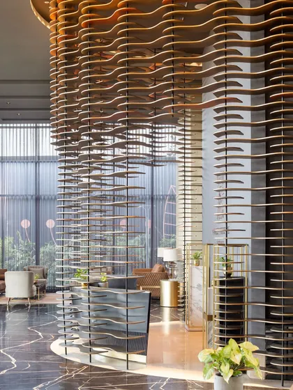 For the Godrej South Estate Experience Centre, we created a design that is an experience in itself. This semi-permeable, curved installation acts as a majestic curtain, balancing openness with intrigue. Crafted from layered MDF plates and illuminated by narrow-beam lights, it transforms a structural element into a piece of art, guiding visitors through a narrative of luxury.