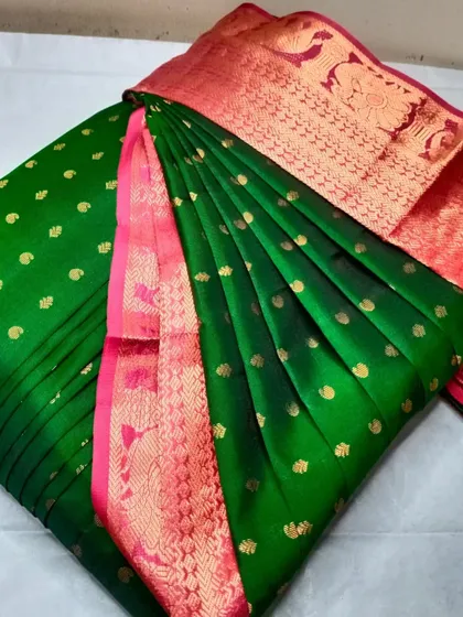 A green and pink silk saree with gold butis.