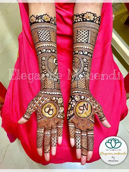 This engagement mehendi was customized with the couple's initials on one palm and interlocking rings on the other. The design is balanced with peacocks and checkered patterns.