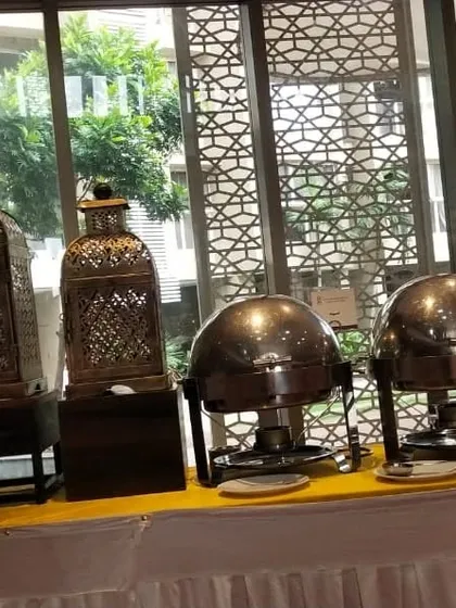 A buffet setup featuring traditional Indian style lanterns and domed chafing dishes. This theme is perfect for adding a classic, ethnic touch to your event.