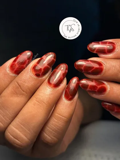 A stunning deep red tortoiseshell or "jelly" nail art design, perfect for an edgy autumn look.