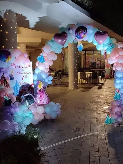 A magical princess-themed entrance for a 6th birthday party. This outdoor setup includes a balloon arch in pastel colors with princess and heart foil balloons.