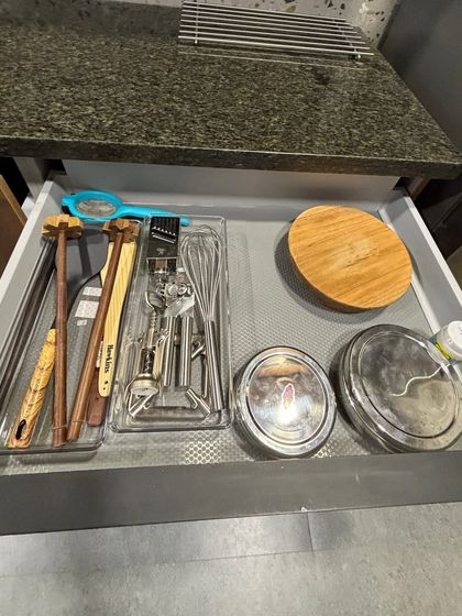 A drawer with miscellaneous cooking tools, including whisks, rolling pins, and a chakla. We use dividers to give each item a clear home.