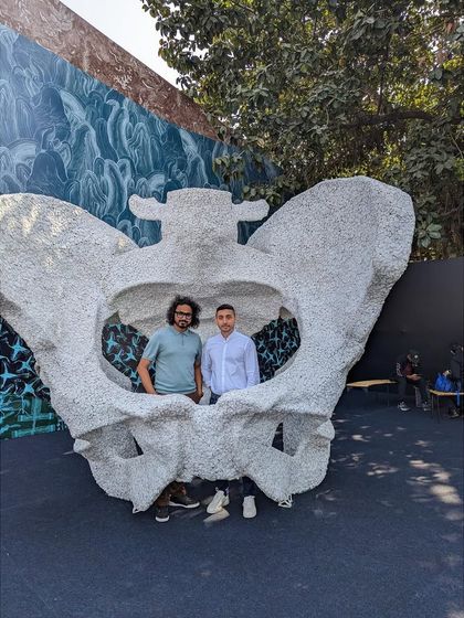 Posing with a visitor inside the 'KAMA' sculpture at the India Art Fair. The piece is designed to be interactive, a photo opportunity that is also a moment of personal connection with the artwork's theme of origin.
