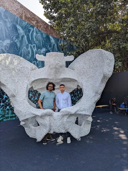 Posing with a visitor inside the 'KAMA' sculpture at the India Art Fair. The piece is designed to be interactive, a photo opportunity that is also a moment of personal connection with the artwork's theme of origin.