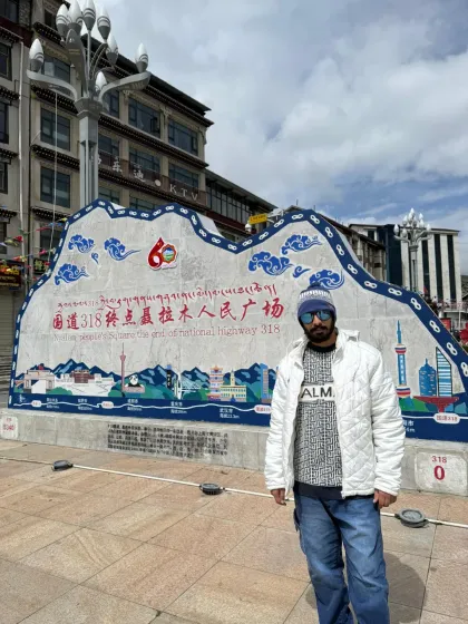 Standing by a monument on the Sino-Nepal Friendship Highway. This road is our path, connecting the world we know to the mystical realm of Kailash.
