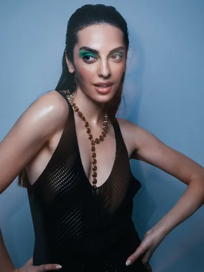 This shot shows the full look, with the bold makeup balanced by a simple, sleek hairstyle and radiant skin.