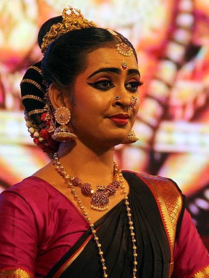 A close-up of a dancer's beautiful expression and traditional makeup during the 'Ayyappa Kavuthuvam' performance.