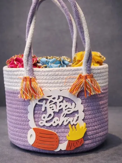 A stylish lavender and white woven jute basket with a "Happy Lohri" cutout, perfect for modern festive gifting.