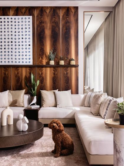 A different angle of the living room, where our client's poodle perfectly complements the warm and inviting decor. The space is designed to be both beautiful and livable.