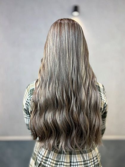 Smoky ash hair color is a cool-toned shade that blends gray and ashy tones for a muted, smoky effect. It's a sophisticated, understated look with a modern edge.