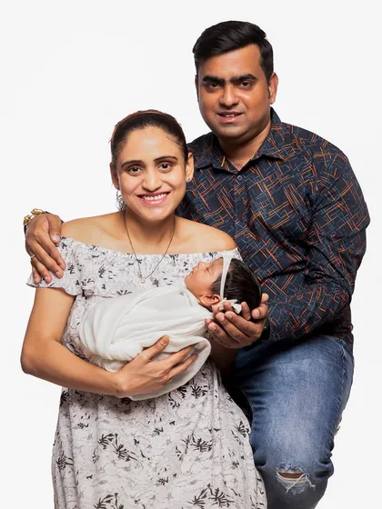 A classic family photograph with both parents and their newborn. This posed studio portrait is a perfect way to formally announce and celebrate your new family of three.