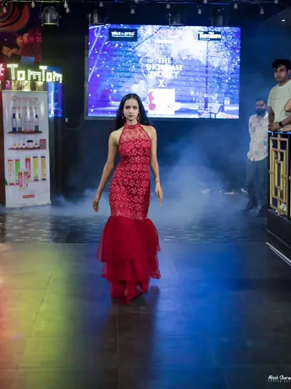 A model emerges through smoke in a stunning red mermaid gown at the 'Walk in Style' event. I use atmospheric elements like smoke and lighting to create dramatic runway photos.