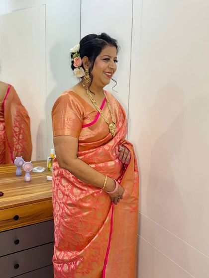 A candid shot of a client in a peach saree, looking happy and radiant.