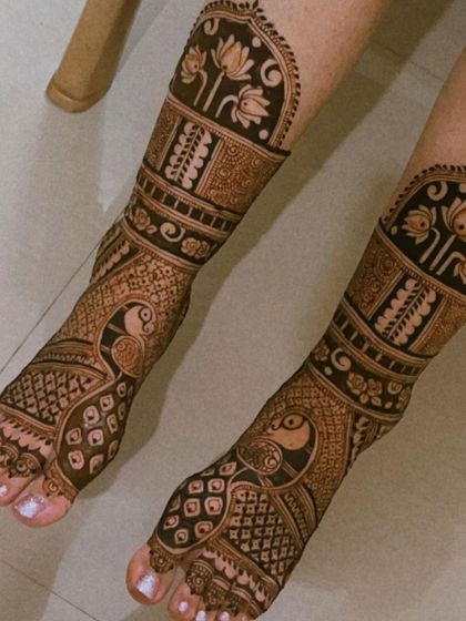 A full-coverage foot design with peacocks and lotus motifs, creating a rich and traditional look for the bride.