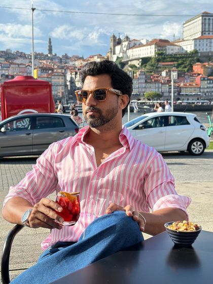 Our candy stripe shirt in pink and white, captured during a leisurely moment in a European city. It's a cheerful and stylish choice for travel and casual outings.