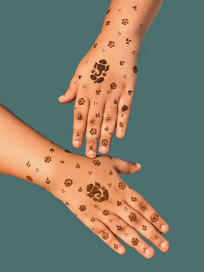 Minimalist mehndi is perfect for guests, kids, or anyone wanting a subtle touch of henna. This simple booti (small motif) design features a central Ganesh figure surrounded by tiny flowers.