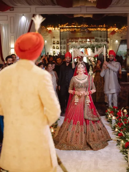The bride's emotional and beautiful entrance, as she walks towards the groom who is waiting for her at the mandap. A truly timeless wedding moment.