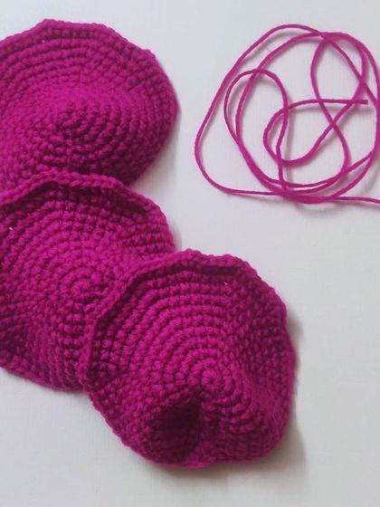 The beginning of a rose. These are the individual petals, crocheted and ready to be assembled. It's a look at the patient process of building a flower from scratch.