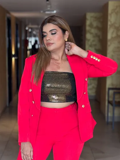 A close-up on the details. The gold buttons and sequin top add that perfect touch of glam to the bold red suit.