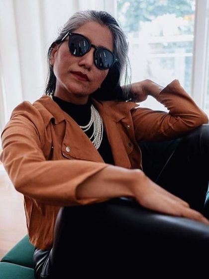 The combination of a classic pearl necklace with a modern biker jacket is a great example of fusion styling.