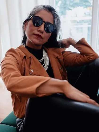 The combination of a classic pearl necklace with a modern biker jacket is a great example of fusion styling.