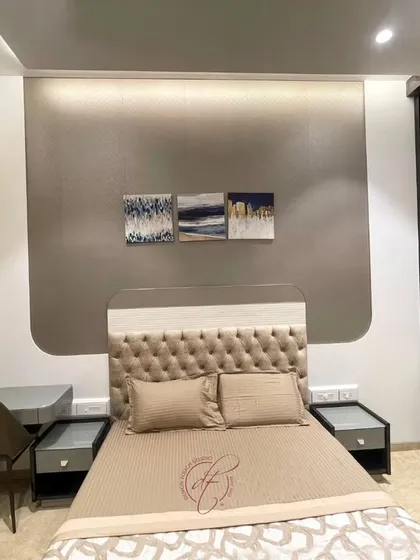 A closer look at the bed and the elegant wall panel behind it. The abstract art adds a personal touch, while the clean lines of the furniture maintain a modern aesthetic.