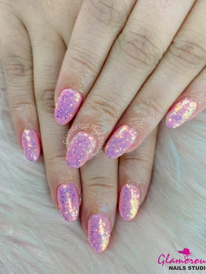 Full-coverage pink iridescent glitter nails that catch the light beautifully, shifting between shades of pink and gold.