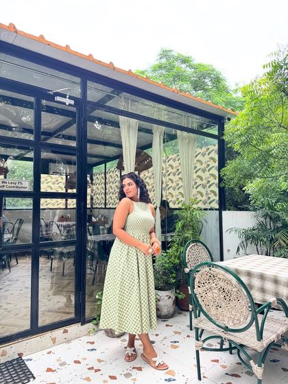 A full-length shot of the green sundress. It's the perfect outfit for a summer day, light, airy, and effortlessly chic.