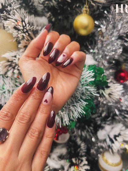 A romantic and moody holiday set. The deep burgundy polish and tiny heart details look stunning against the festive backdrop of a Christmas tree.