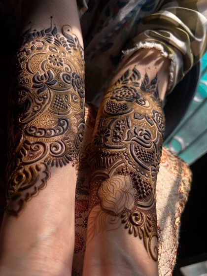 A shot of the bridal henna in the sunlight. The contrast between the dark paste and the skin highlights the intricate details of the floral and paisley work.