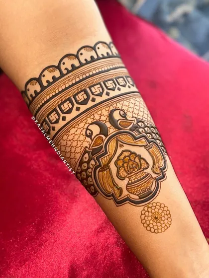 This arm cuff is rich with traditional symbols: a mini elephant for good fortune, a swastika for blessings, and a peacock with a kalash for prosperity.